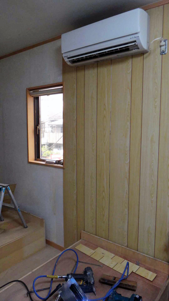 壁に木質建材を貼っているところ